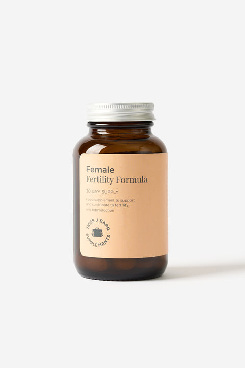 Les suppléments Female Fertility Formula de Ross J Barr dans une bouteille en vitre sur fond blanc.