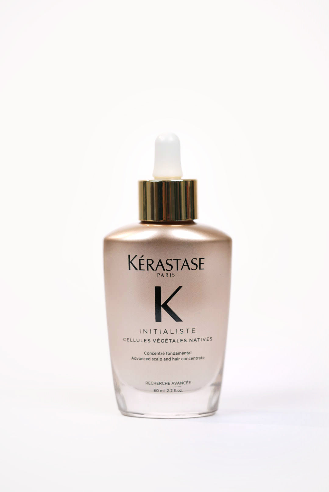 Une bouteille rose gold avec une pipette blanche et contour doré.