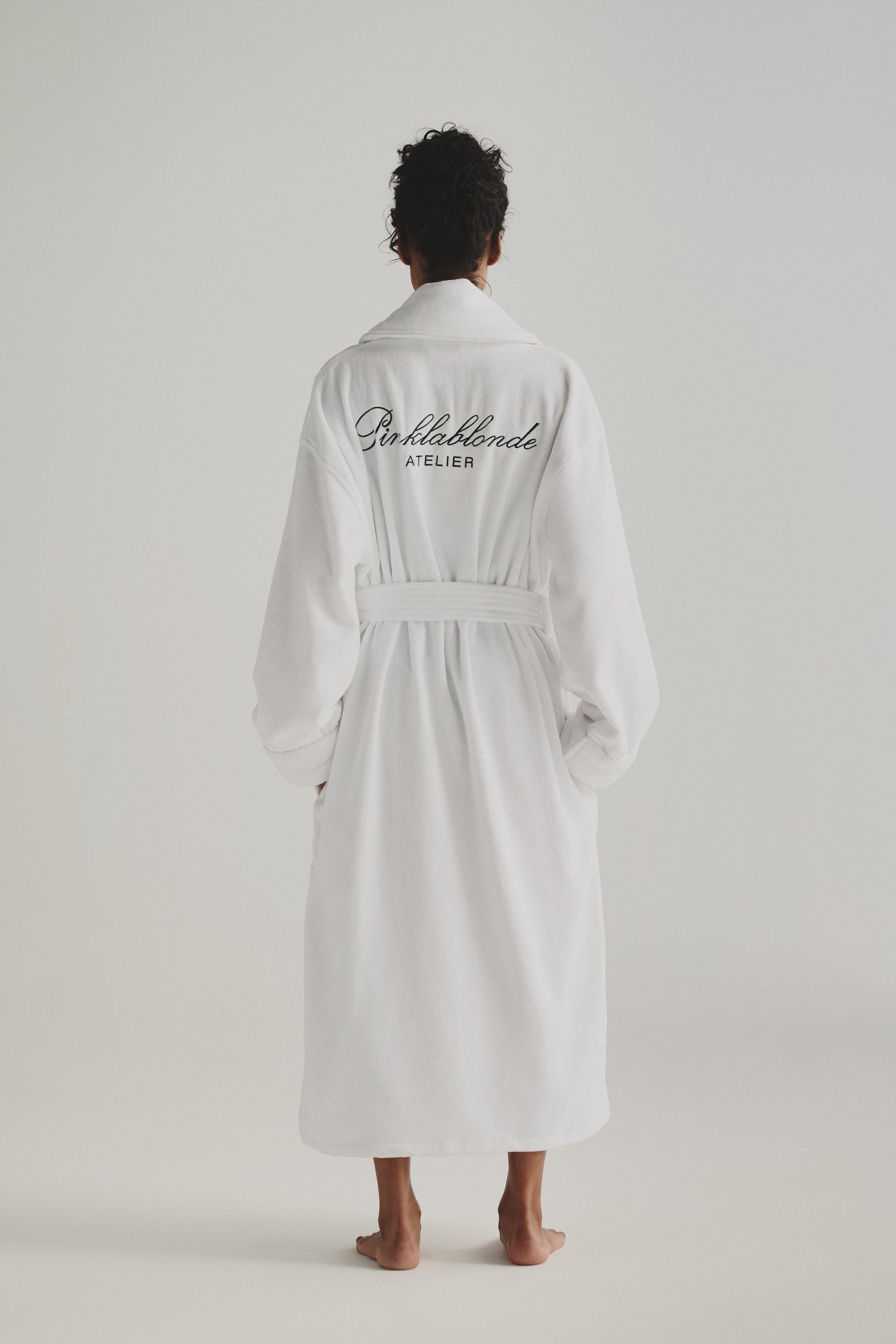 Une femme de dos porte la robe Pinklablonde Atelier.