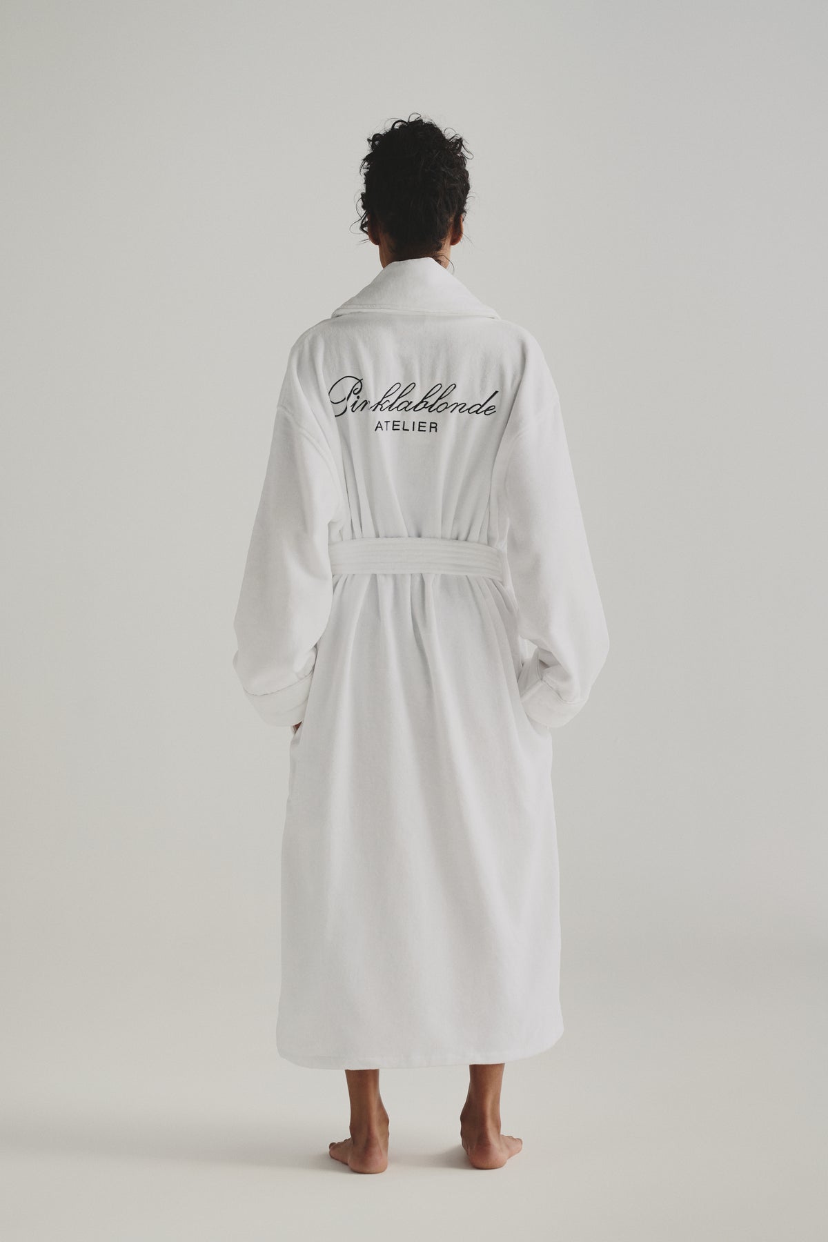 Une femme de dos porte la robe Pinklablonde Atelier.