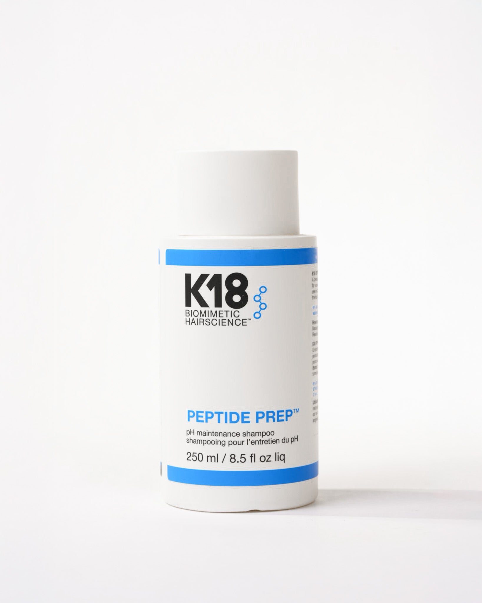 Bouteille blanche et bleu du shampooing pour l'entretien du pH peptide prep k18